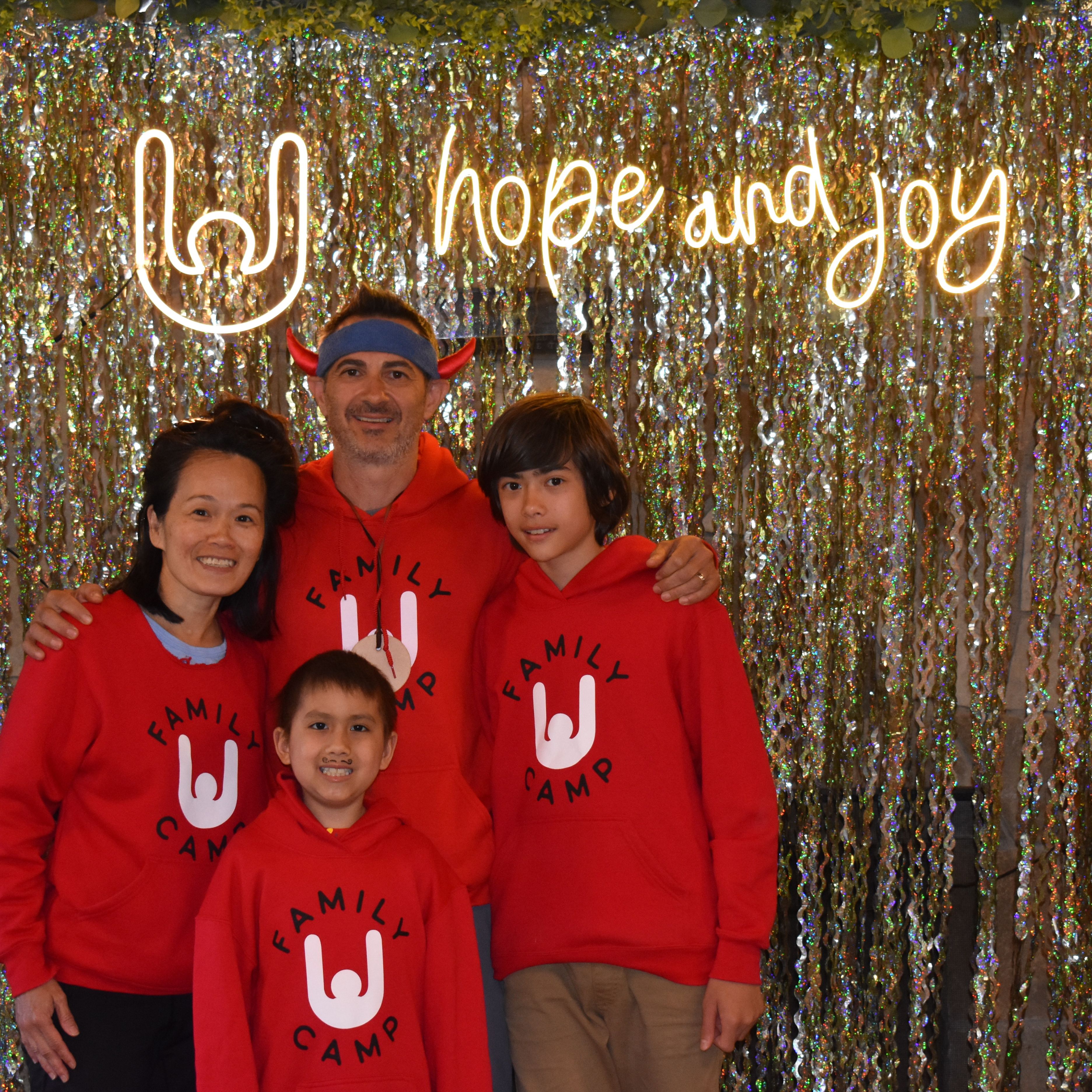 Family photo in front of hope and joy sign 