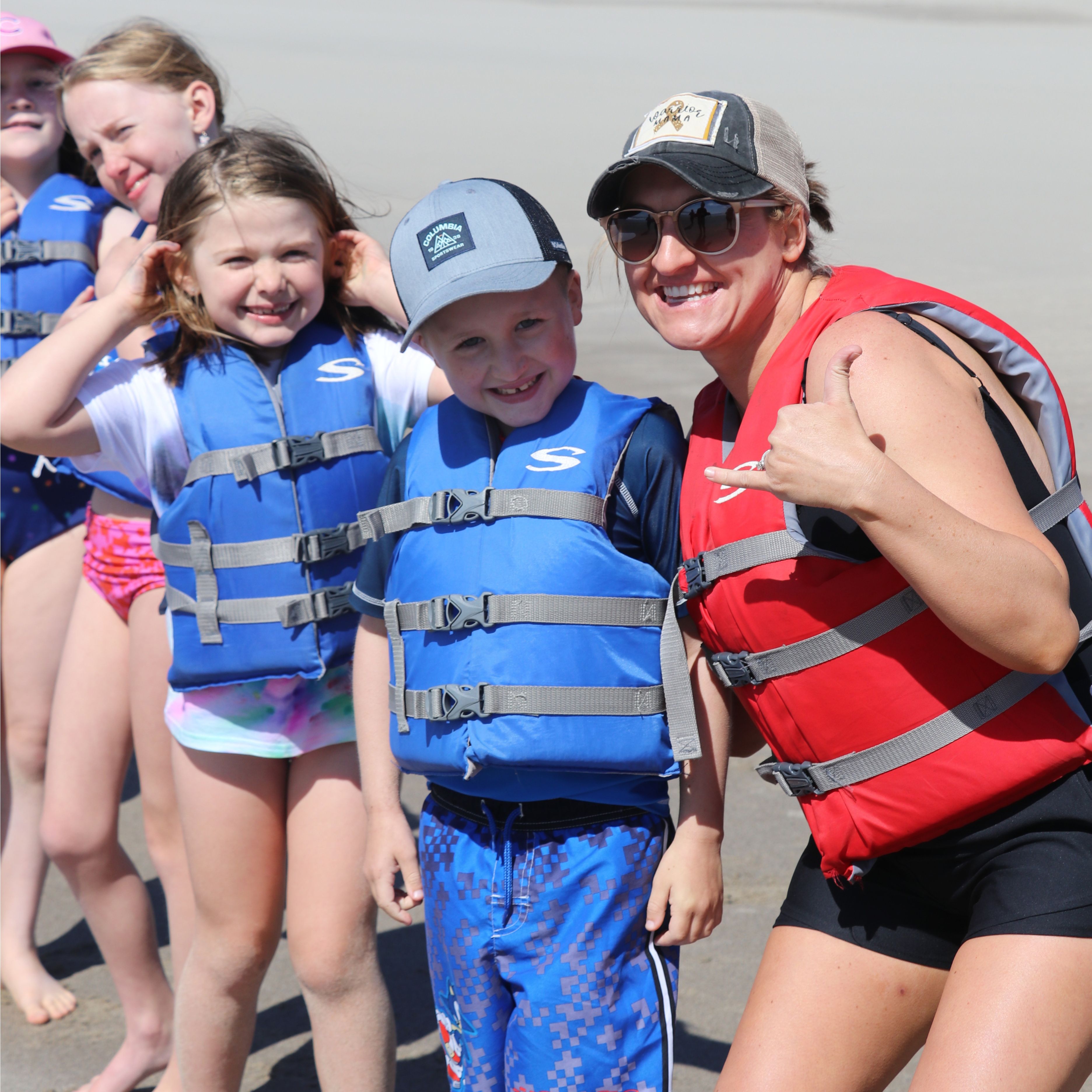 Campers and parent smiling in life jackets