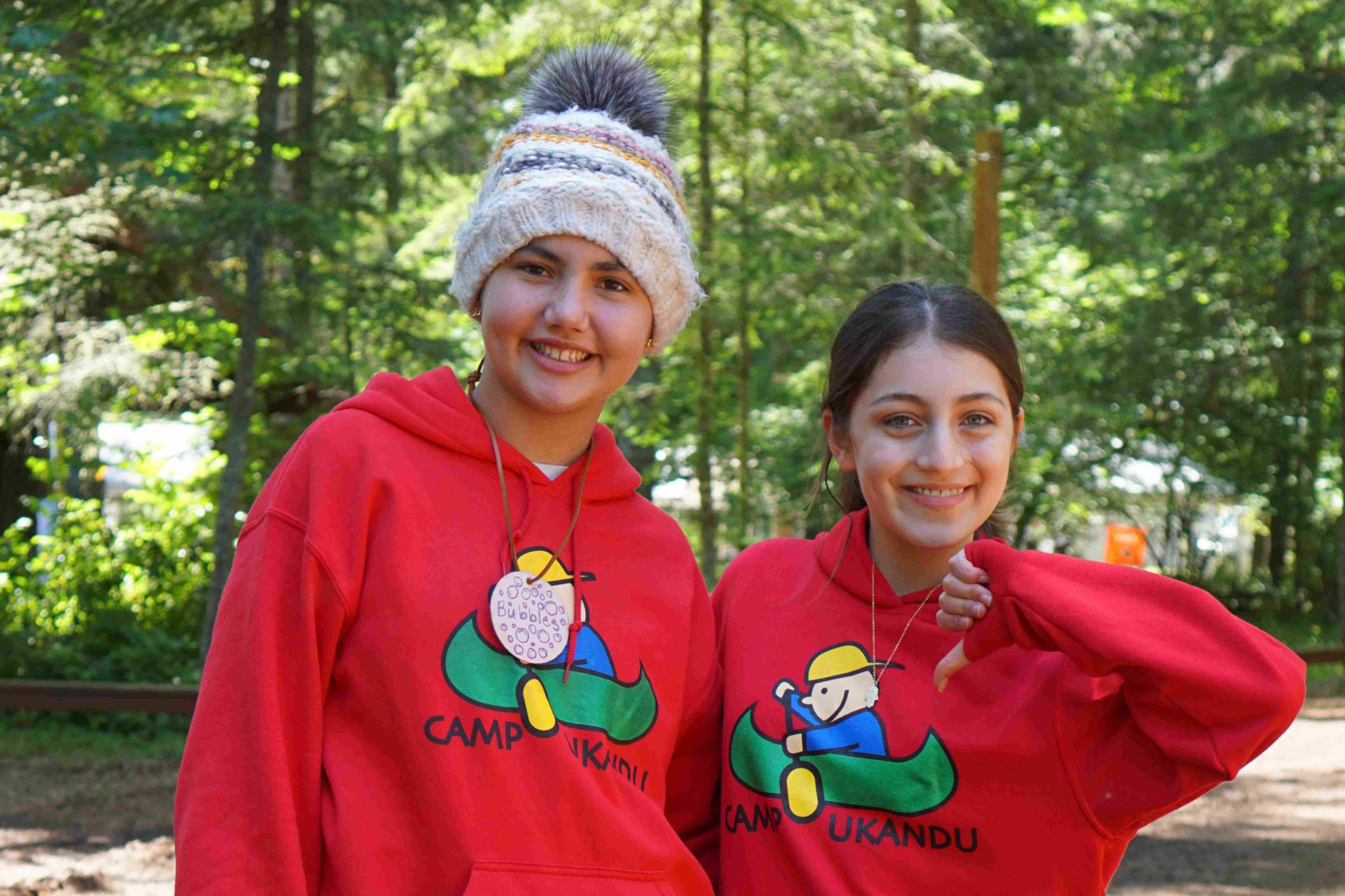 Two girls smiling in Camp Ukandu sweatshirts