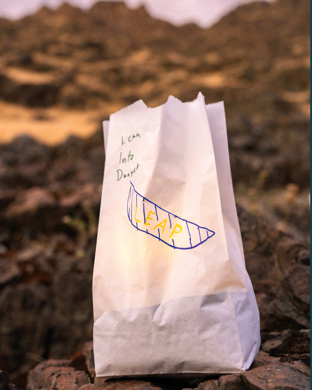 photo of luminary with a hand drawn picture of a canoe that reads "Lean Into Danger" 